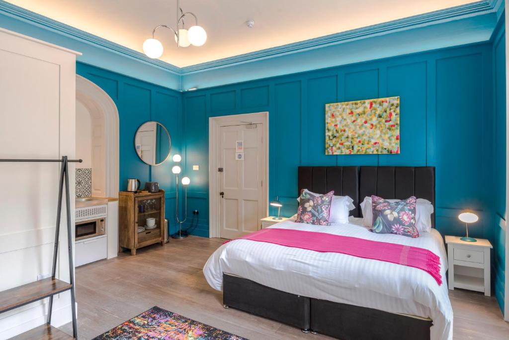 een slaapkamer met blauwe muren en een groot bed bij 4 Berkeley Square I Your Apartment in Bristol