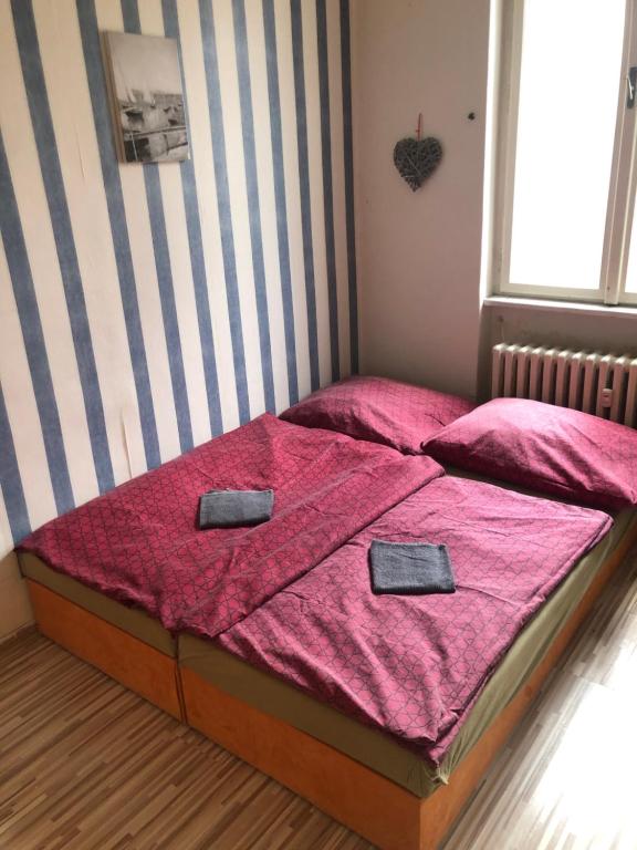 Schlafzimmer mit einem Bett mit rosa Bettwäsche und einem Fenster in der Unterkunft Easy Backpacker Old Town in Košice