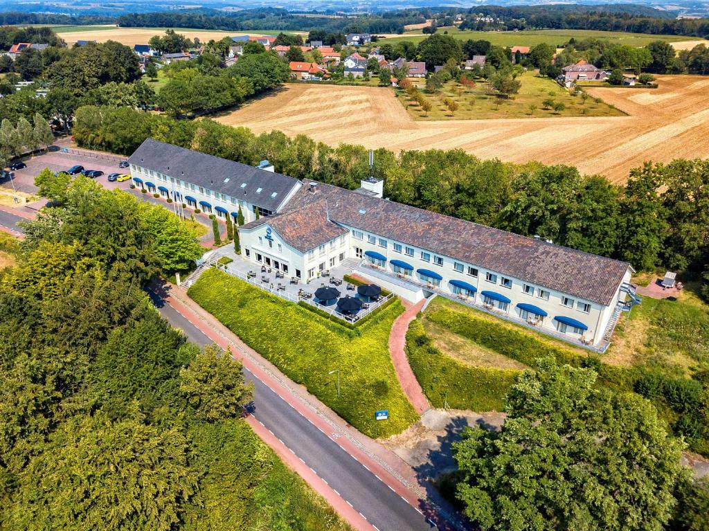 eine Luftansicht auf ein großes weißes Gebäude mit einem Hof in der Unterkunft Best Western Hotel Slenaken in Slenaken