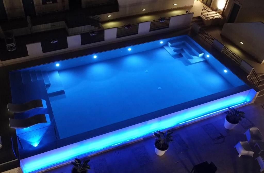 an overhead view of a swimming pool with blue lights at Hotel Baglio Di Scopello in Scopello