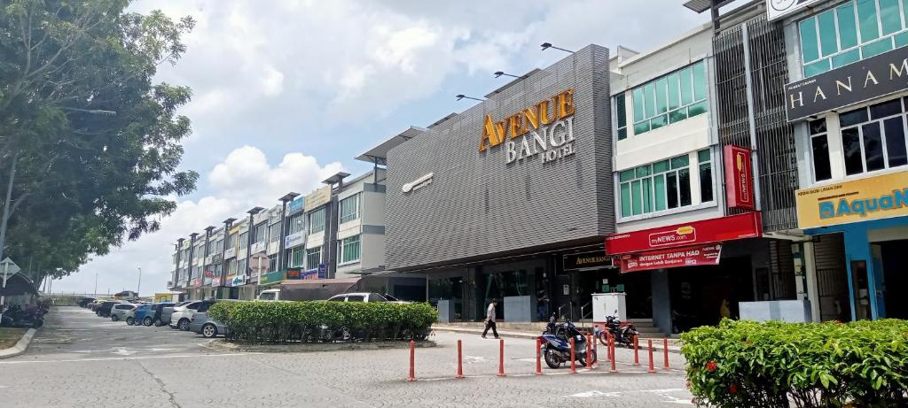 een rij gebouwen in een stadsstraat met geparkeerde auto's bij AVENUE BANGI HOTEL in Kajang