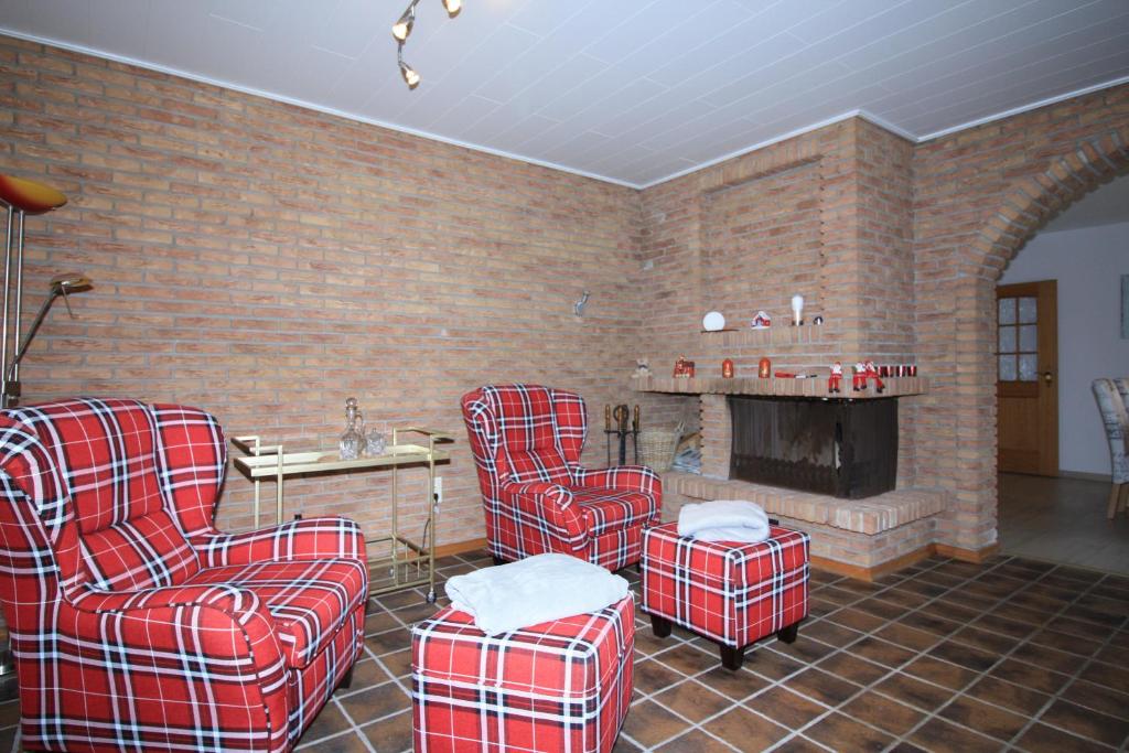 ein Wohnzimmer mit roten Stühlen und einem Kamin in der Unterkunft Ostfreesenhuus Vier Pfoten in Marienhafe
