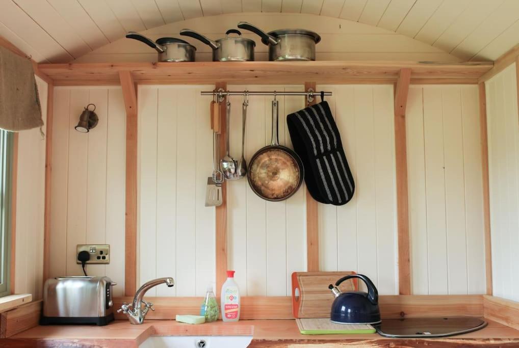 a kitchen with a counter with pots and pans on the wall at The shepherds hut in Shrewsbury