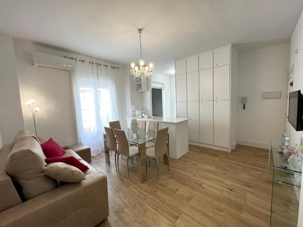 een woonkamer en eetkamer met een bank en een tafel bij Apartamento Centro Alhóndiga Suite in Granada