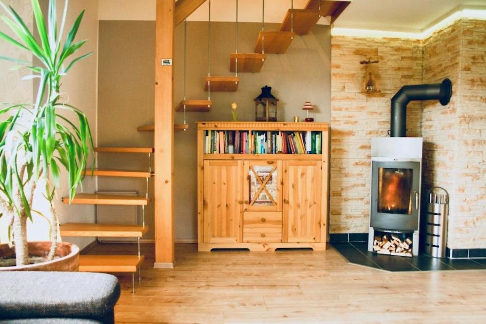 ein Wohnzimmer mit einem Holzofen und einer Treppe in der Unterkunft Urlaub in Crottendorf für bis zu 8 Personen in Crottendorf