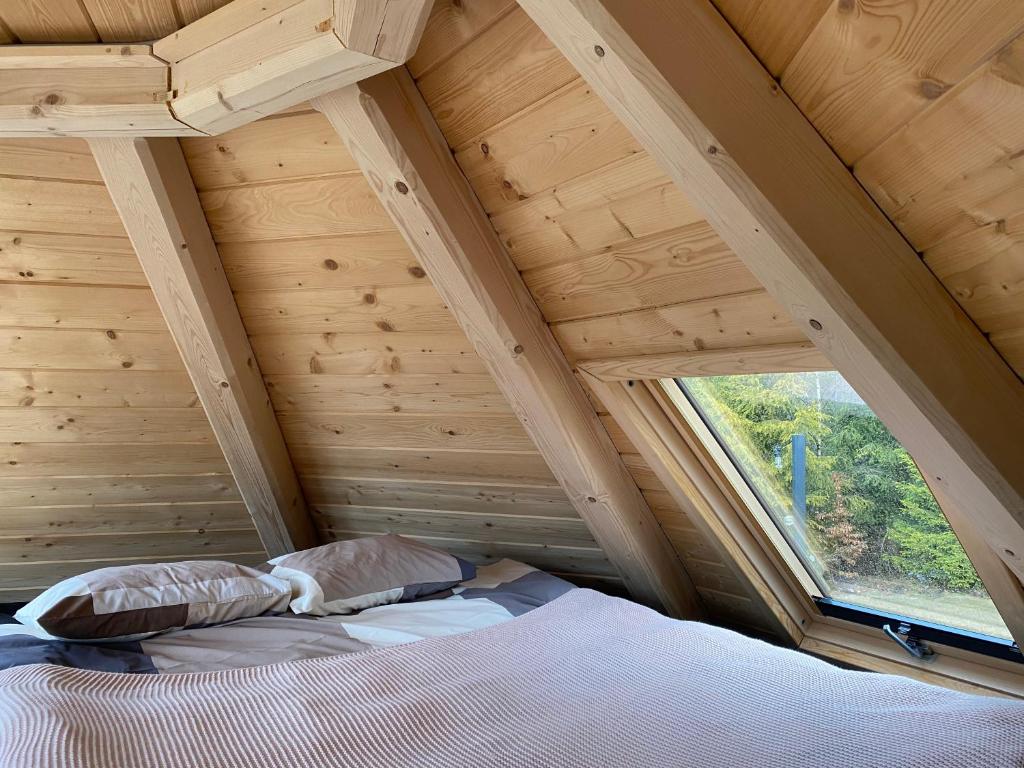 łóżko w pokoju z dużym oknem w obiekcie Osada Poli - domek 3 w mieście Koniaków