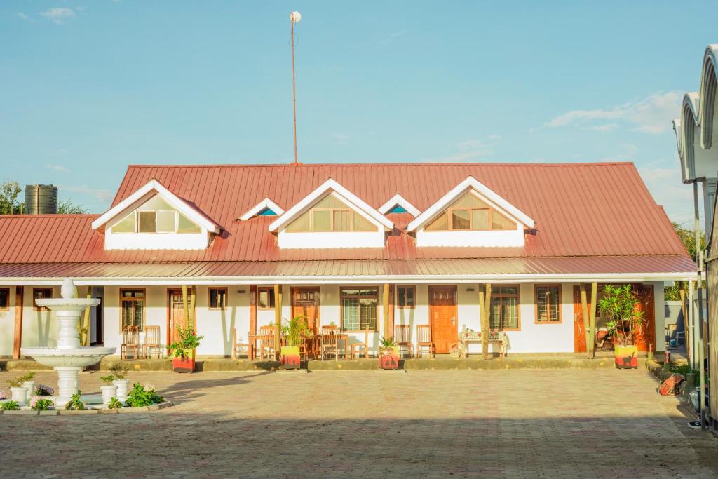 a large white building with a red roof at Heart of Africa Lodge in Arusha