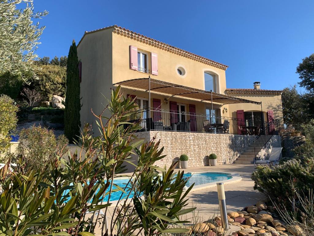 uma casa com uma piscina em frente em Villa Madou em Rochefort-du-Gard