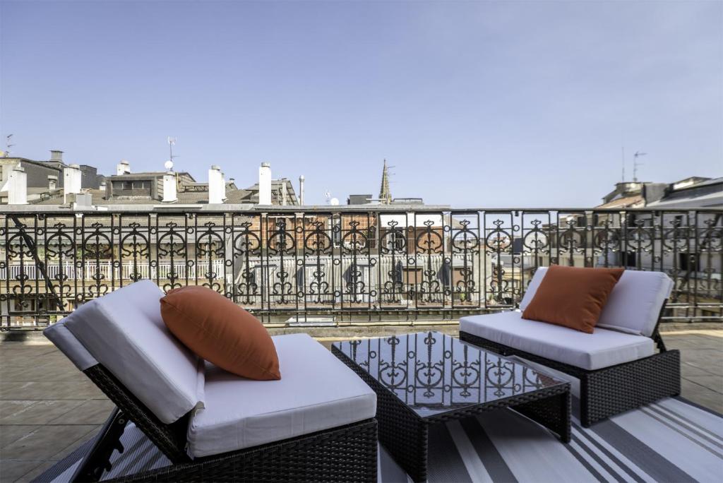 dwa krzesła i stół na balkonie w obiekcie Always Easy I Suite Terraza w mieście San Sebastián