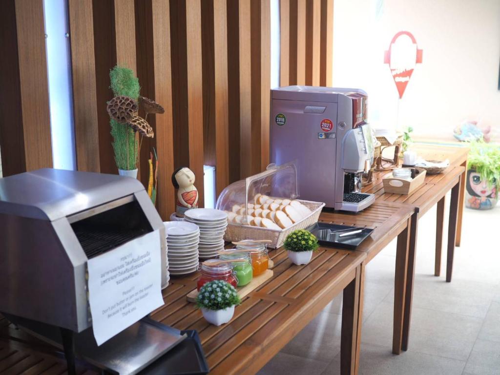 A self-service breakfast counter includes a coffee machine, bread, spreads, and tableware.