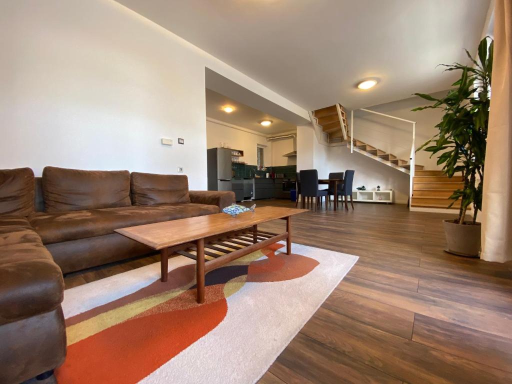 un soggiorno con divano marrone e tavolino da caffè di 2 bedroom 107 m2 loft with balcony a Budapest