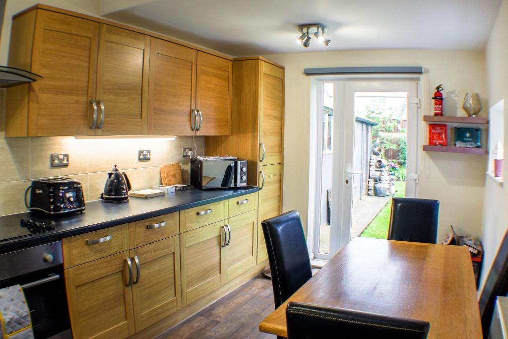 a kitchen with wooden cabinets and a table with chairs at 18 Sea View Close in Scarborough