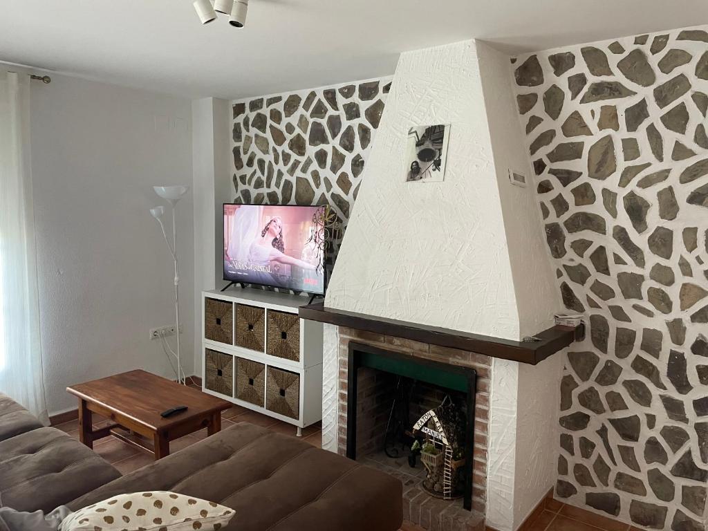 a living room with a fireplace with a flat screen tv at Alojamiento EL BUTAKA in Cala
