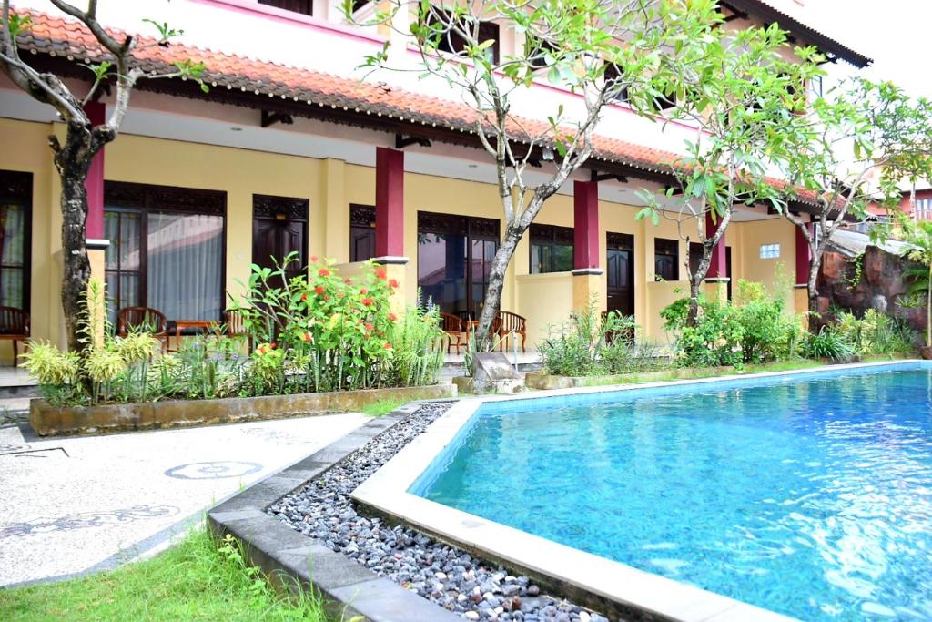 a swimming pool in front of a building at Celebbest in Kuta