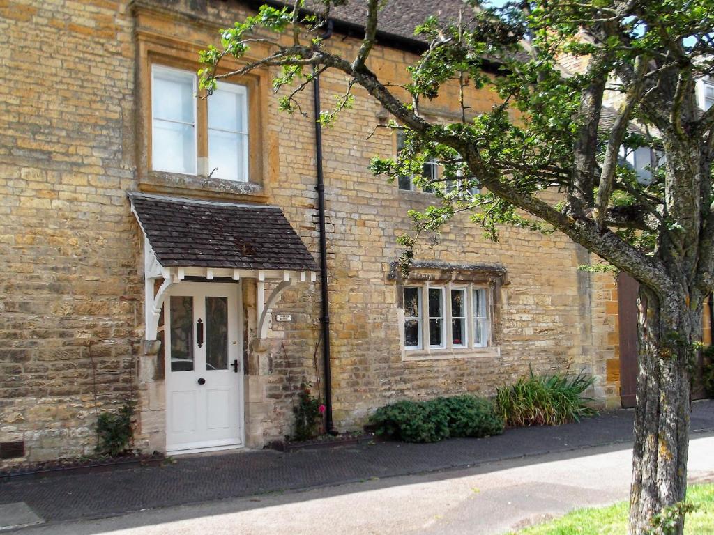 a brick house with a white door at Ruskin House in Moreton in Marsh