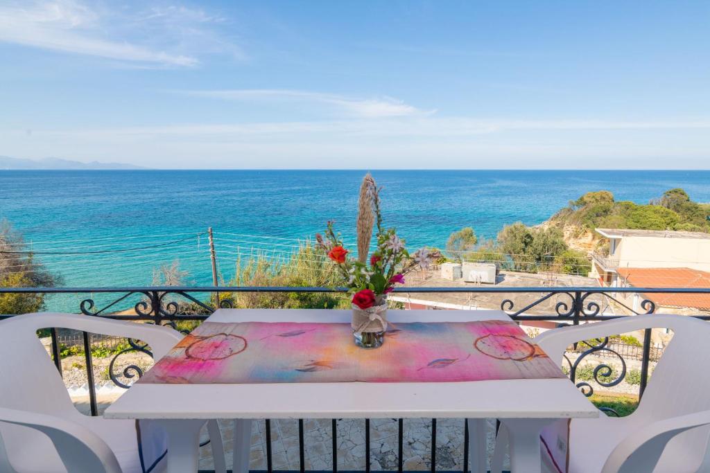 una mesa en un balcón con vistas al océano en Agnadi Sea View Apartments, en Alikanas