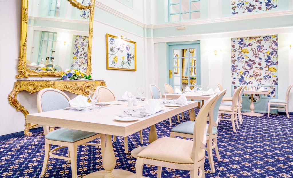 a dining room with tables and chairs and a mirror at AX The Victoria Hotel in Sliema