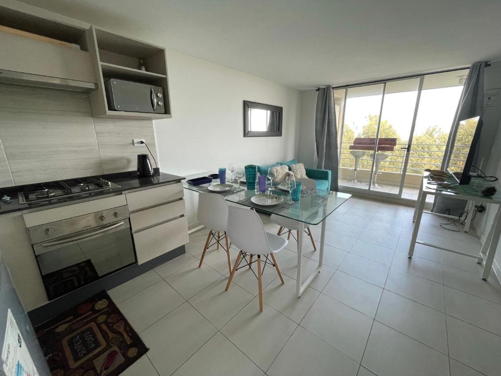 a kitchen with a table with chairs and a stove at Nuevo departamento algarrobo in Algarrobo