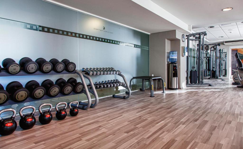 a gym with rows of dumbbells on a wall at AX The Victoria Hotel in Sliema