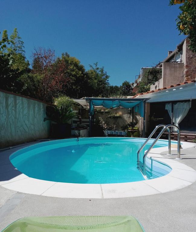 une grande piscine dans une cour avec une clôture dans l'établissement BELLE MAISON DE CARACTERE Dans VILLAGE et sa PISCINE Privée 7 PERS- 3 Chambres - 12 Rue Emile Zola, à Millas