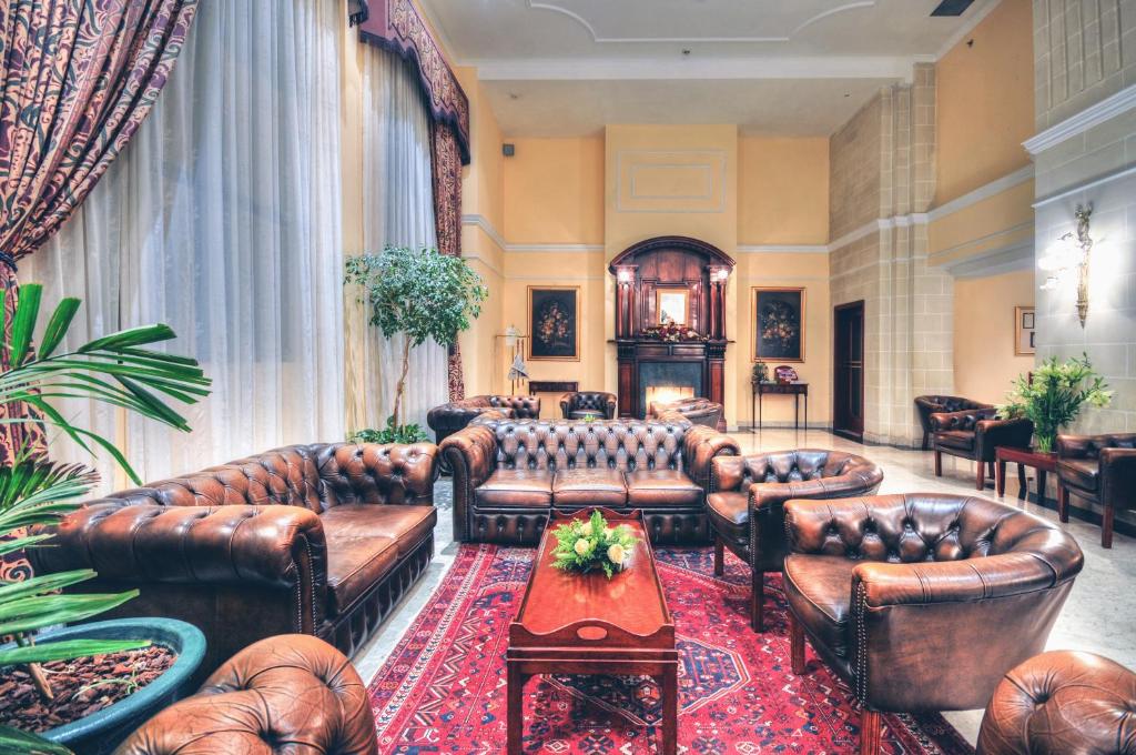 a living room with leather couches and a table at AX The Victoria Hotel in Sliema