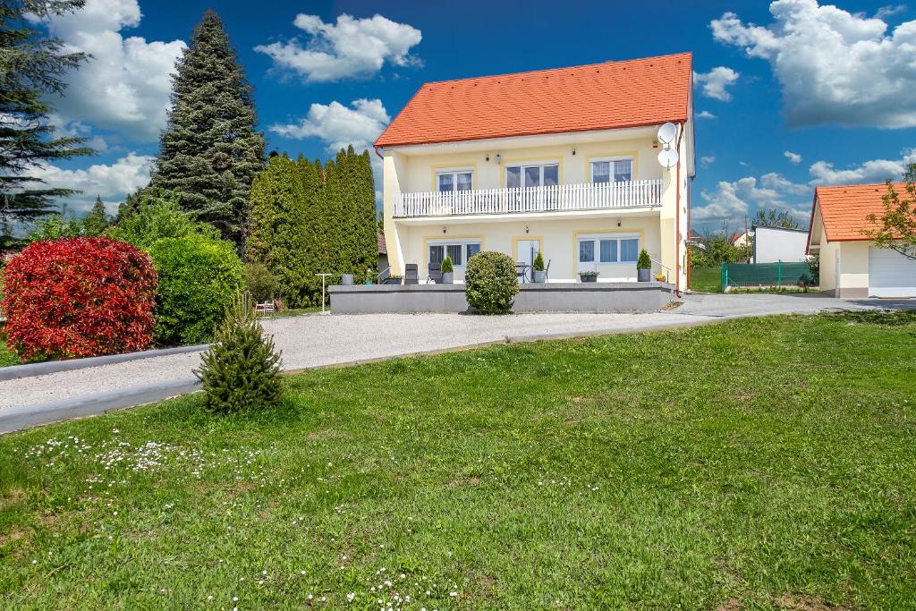 una casa blanca con techo naranja y patio en Ági apartman Cserszegtomaj, en Cserszegtomaj