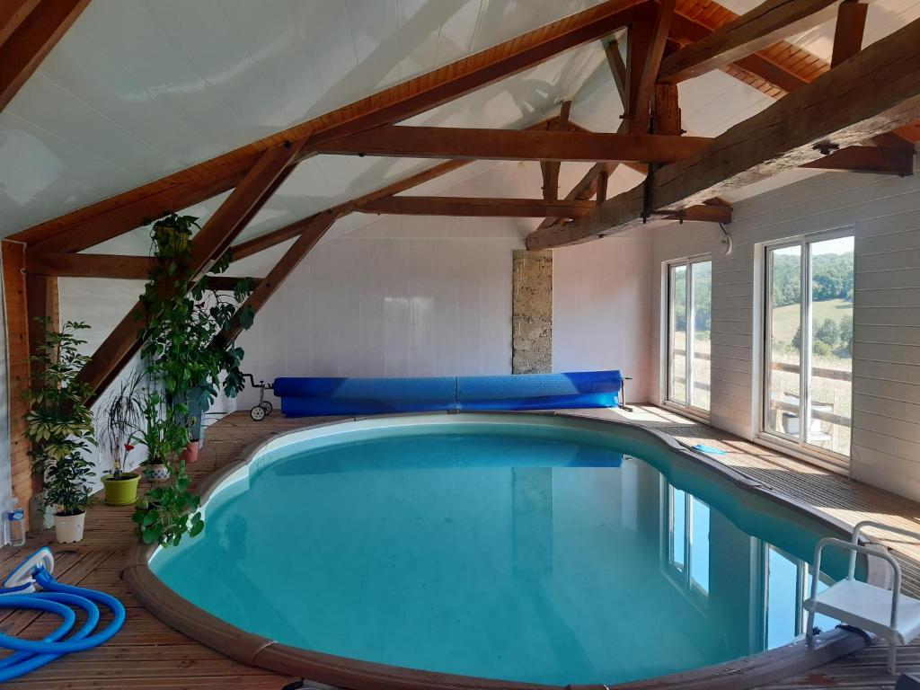 uma piscina interior numa casa com tectos em madeira em le Trésor de Gabaret em Burosse-Mendousse