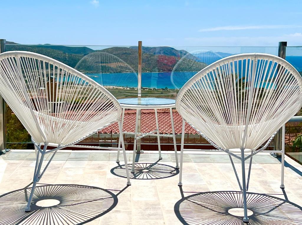 two chairs and a table on a balcony at Sea view 4 bedrooms, 3 bathrooms Cottage in Anavyssos