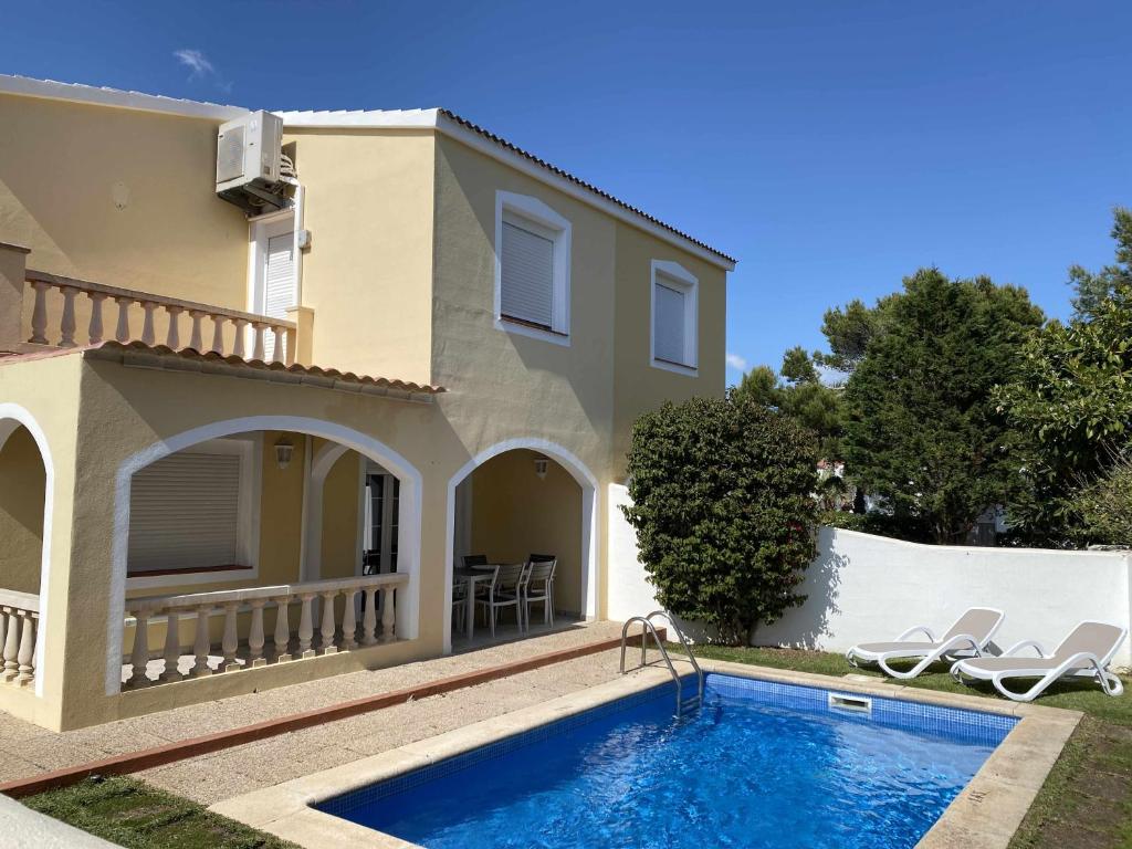 Villa con piscina frente a una casa en Chalet Villafranca Menorca con piscina privada, en Cala'n Bosch