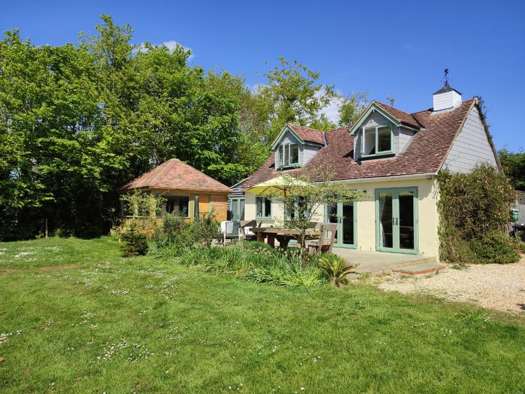 une maison avec une cour dotée d'une pelouse dans l'établissement Little Fisher Farm - Farm-View Retreat, à Chichester