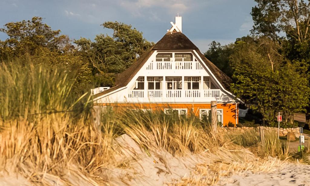 een oranje en wit huis bovenop een strand bij Strandhaus Claassen 06 in Ahrenshoop