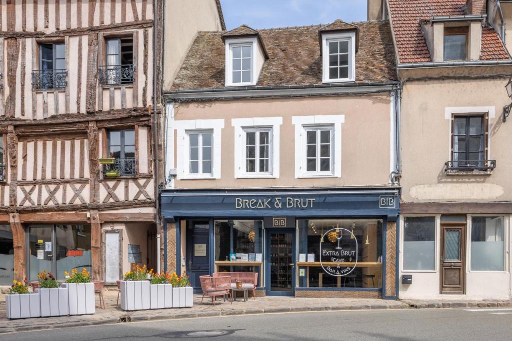 une rue avec des bâtiments et un magasin noir et tampon dans l'établissement Break & Brut, à Nogent-le-Roi