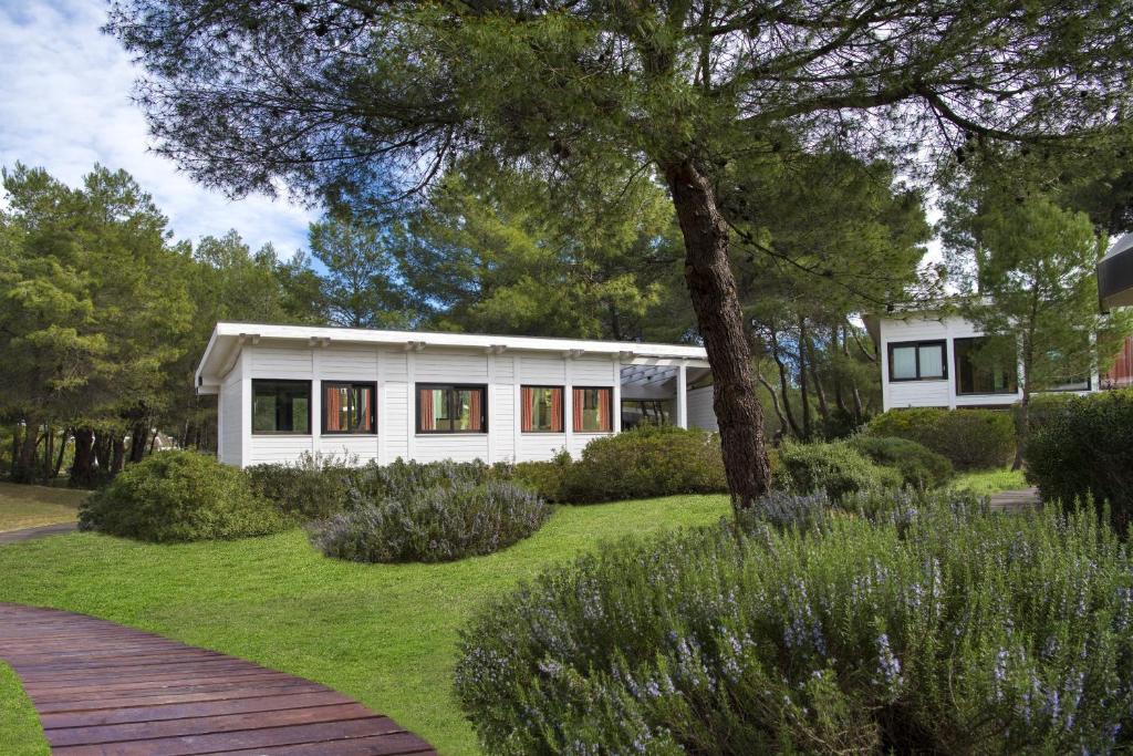 a white house with a garden in front of it at Ethra Reserve Alborèa in Castellaneta Marina