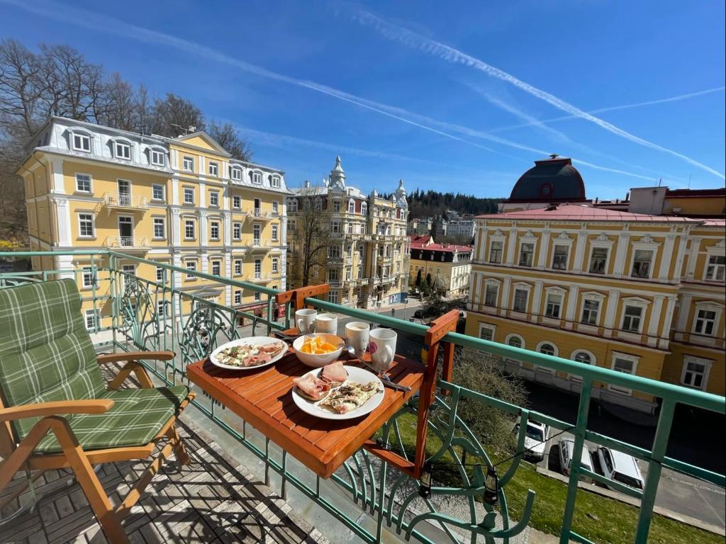 マリアーンスケー・ラーズニェにあるBalconies above colonnade apartmentsのバルコニー(テーブル、食べ物付)