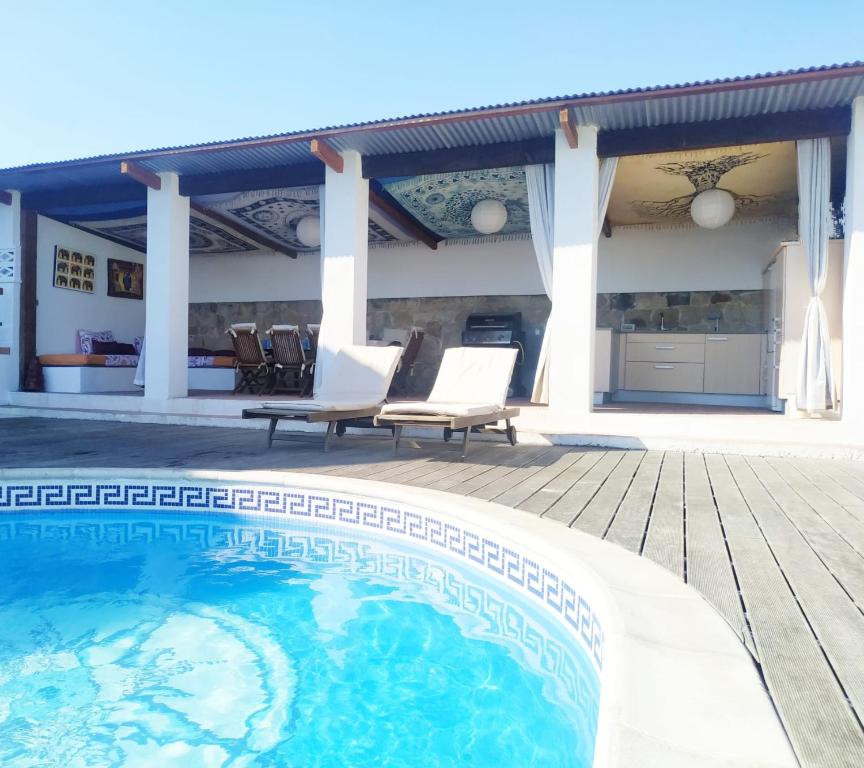 una piscina con sedie e una casa di Camino a Casa - Suances a Hinojedo