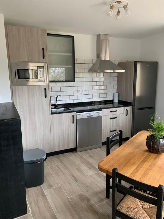 a kitchen with a table and a refrigerator and a stove at Marquina Rural in Cubillo del Butrón