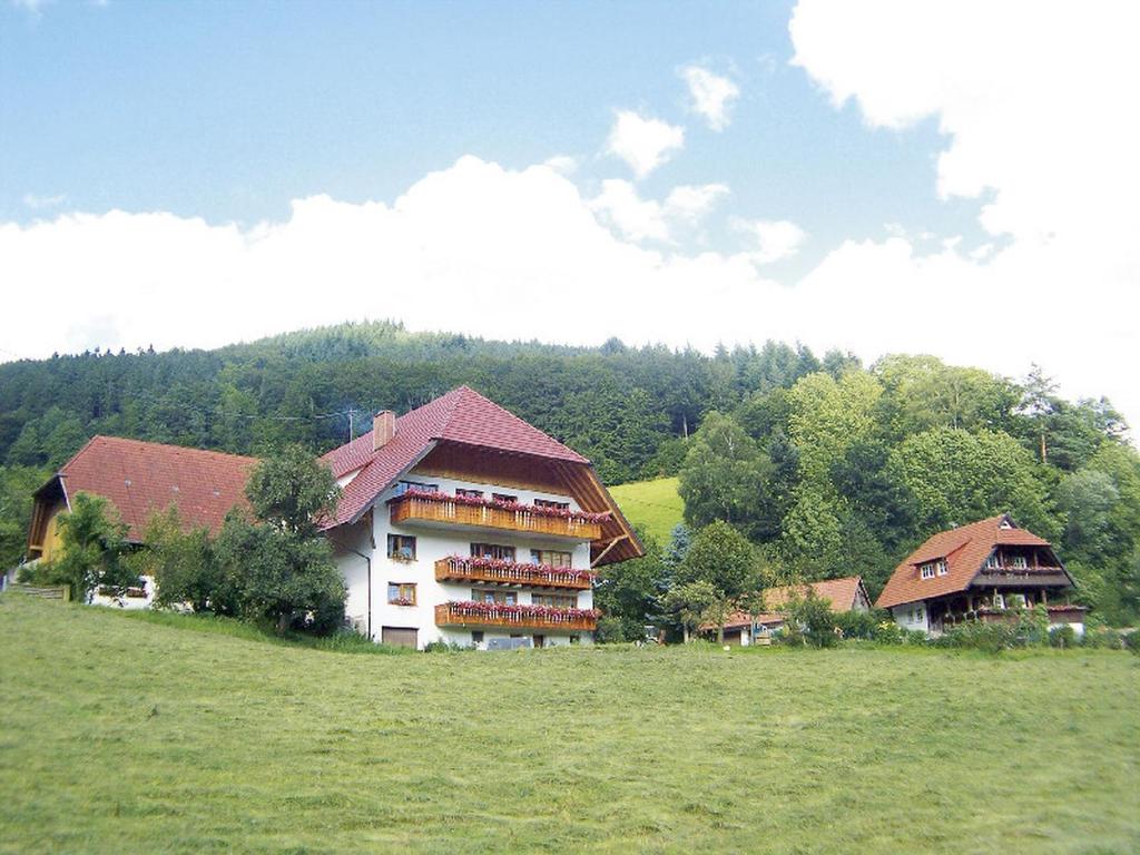un gran edificio en un campo con árboles en el fondo en Geigerbauernhof, en Mühlenbach