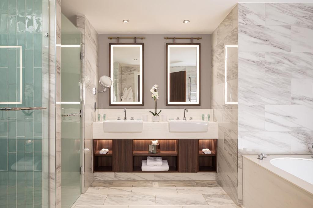 a bathroom with two sinks and a tub and a shower at The Parkgate Hotel in Cardiff