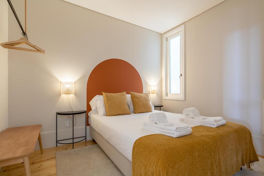 een slaapkamer met een bed met twee handdoeken erop bij Habitatio - Aliados in Porto