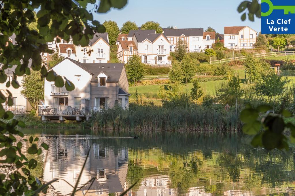 a large house on the side of a lake at Village Pierre & Vacances Normandy Garden in Branville