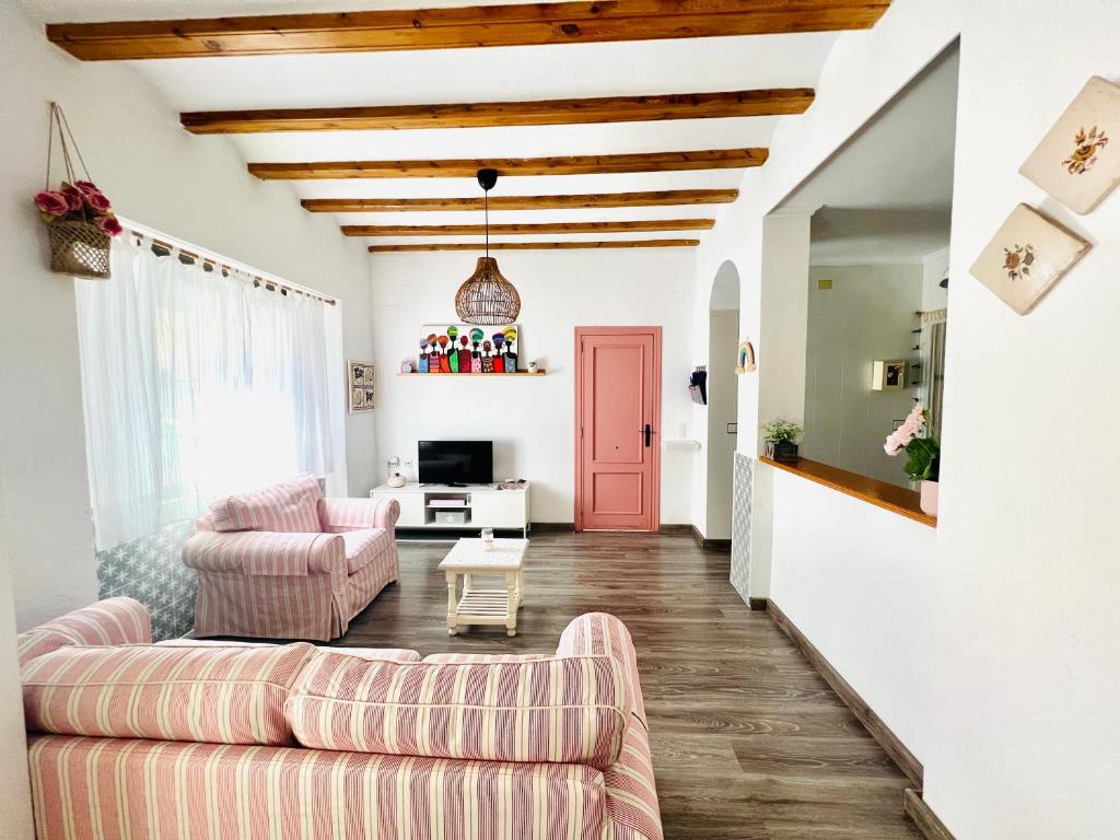 sala de estar con sofá y puerta roja en Villabett Caudiel está de moda, en Caudiel