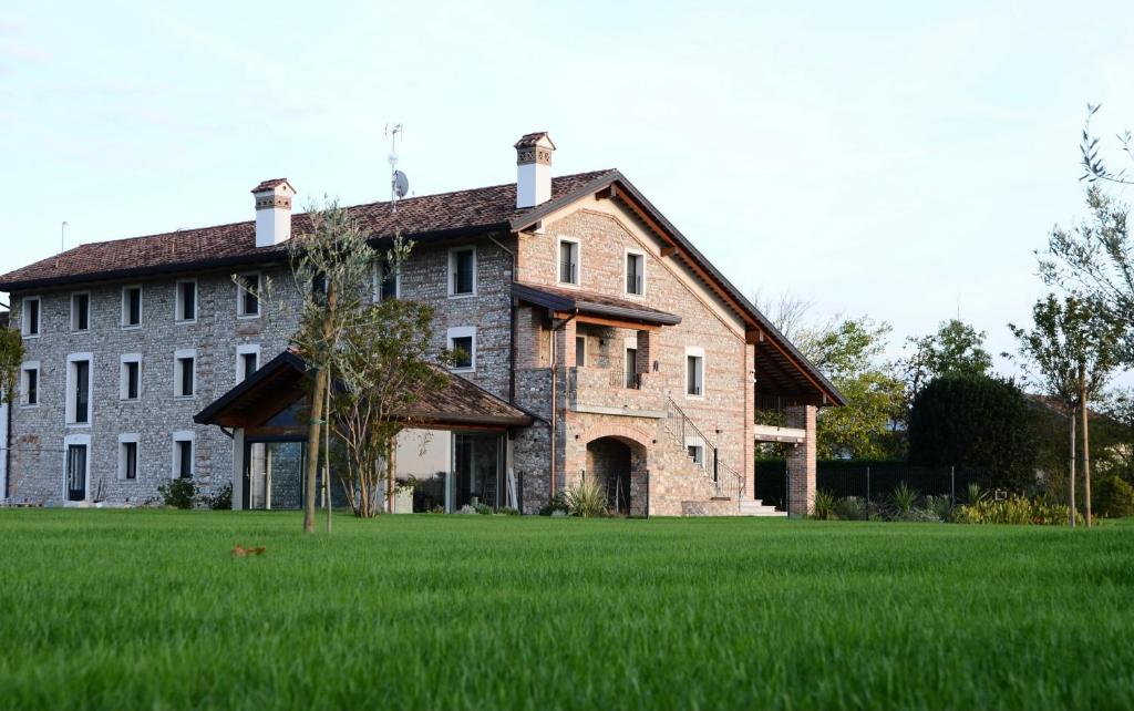un gran edificio de ladrillo en un campo de hierba en Atmosfere Charme & Country, en Udine