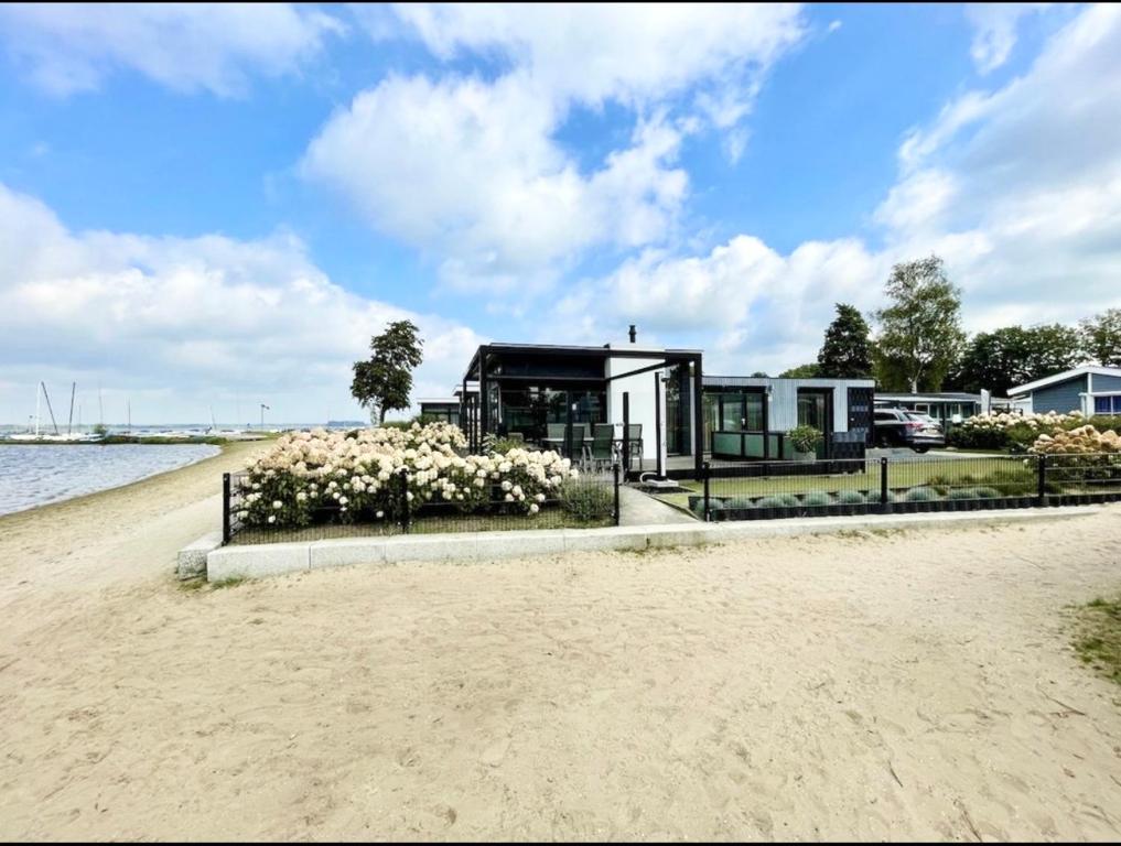 une maison sur la rive d'une plage dans l'établissement Luxus Cube Meerblick Veluwemeer am Strand in erster Reihe, à Hulshorst
