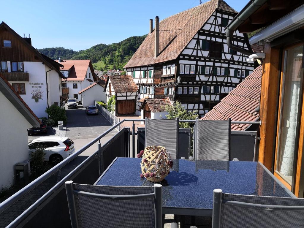 a table on a balcony with a view of a town at OBSTHAUS Ferienwohnung Apfel in Sipplingen