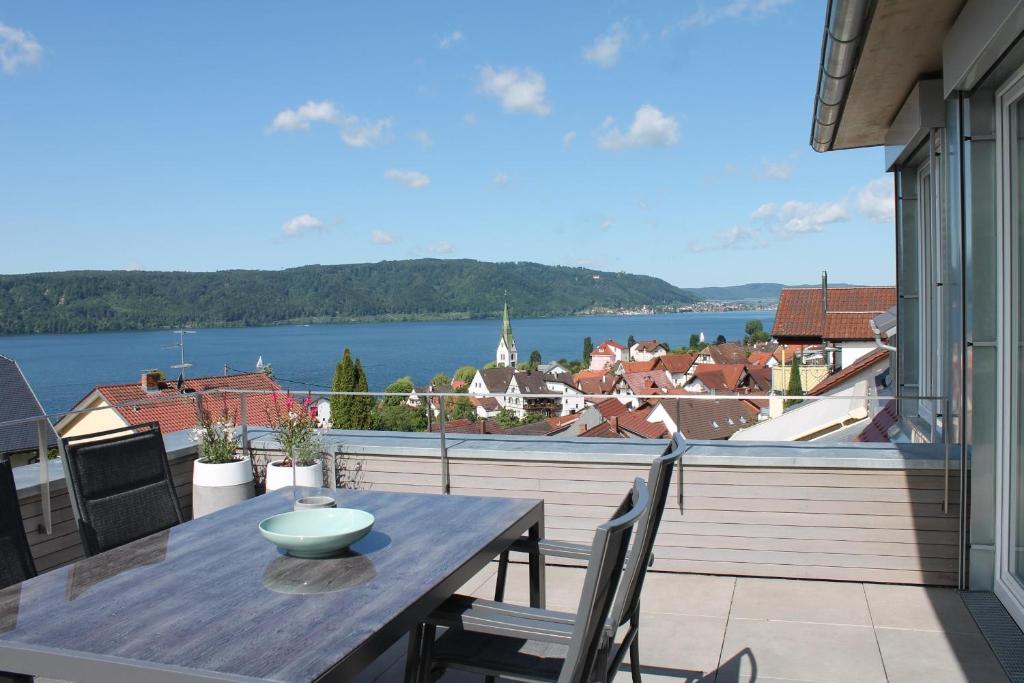 - une table sur un balcon avec vue sur l'eau dans l'établissement REBHAUS Ferienwohnung Rebdach, à Sipplingen