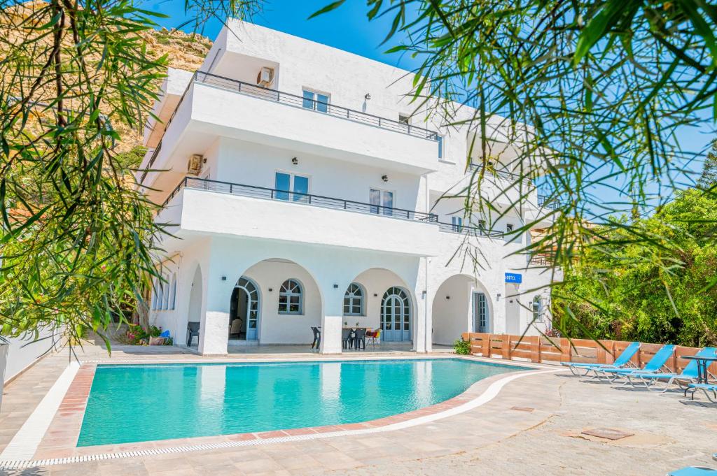 une villa avec une piscine en face d'un bâtiment dans l'établissement Matala Hostel, à Matala