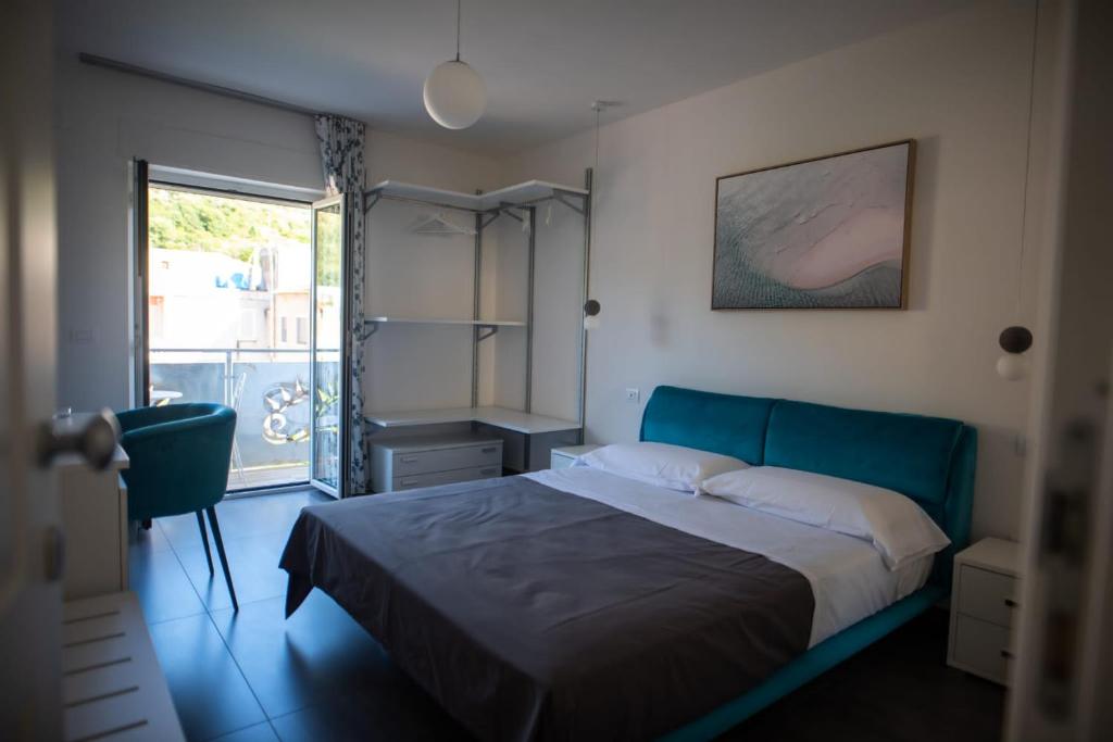 a bedroom with a blue bed and a window at Casa Lombardi in Santa Maria di Castellabate