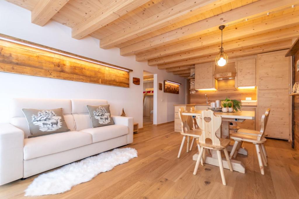 a living room with a white couch and a table at Chalet Laura in Alleghe