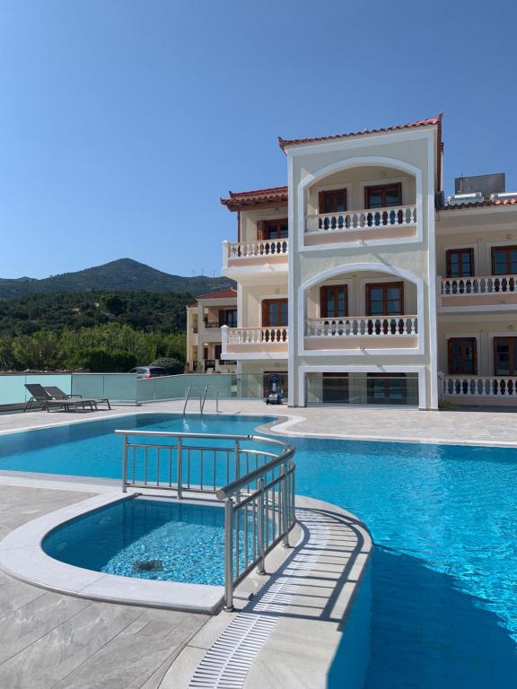 a large building with a swimming pool in front of it at Anemos Apartments in Marathokampos
