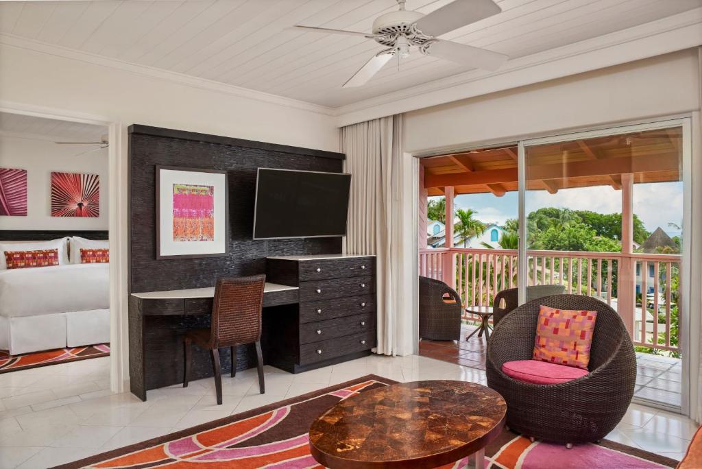 a bedroom with a desk and a bed and a table at Crystal Cove, Barbados, A Tribute Portfolio All-Inclusive Resort in Saint James